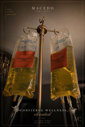 Two hanging IV vitamin drip bags filled with golden-yellow solution labeled “Performance Mode,” suspended from a polished metal IV stand in an upscale concierge wellness setting.