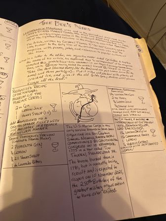 Handwritten notebook page titled "The Bee's Knees" displaying cocktail recipes (gin, lemon, honey syrup), bartending notes, a hand-drawn eagle-and-globe sketch, and short U.S. Marine Corps history notes.