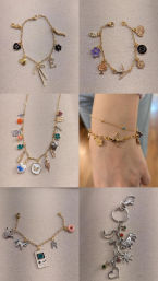 Flatlay collage of assorted charm jewelry: multiple gold charm bracelets with bows, initials, flowers, birds, a mini Game Boy and donut charm, one silver charm keychain, and a photo of stacked bracelets on a wrist, displayed on beige fabric.