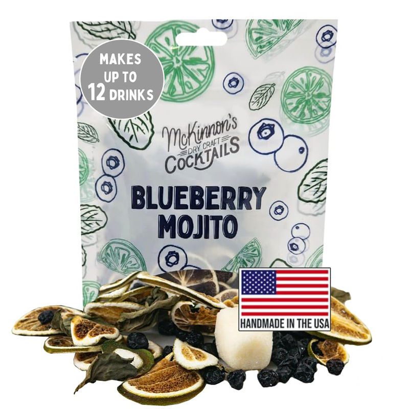 Pouch of Blueberry Mojito cocktail mix surrounded by dried lime slices, dried blueberries and mint leaves with an American flag “Handmade in the USA” label — American-made cocktail mix.