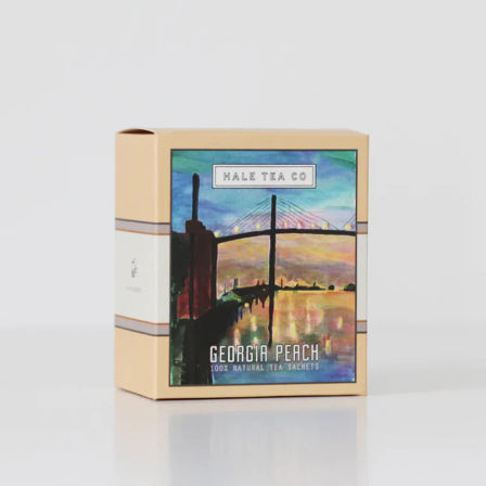 Vibrant box of Georgia peach tea sachets featuring a painted suspension bridge at sunset with colorful sky and water reflection
