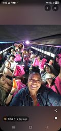 Group of smiling women on a lively party bus, selfie from the front showing pink swag bags, drinks and LED strip lights during a celebratory outing