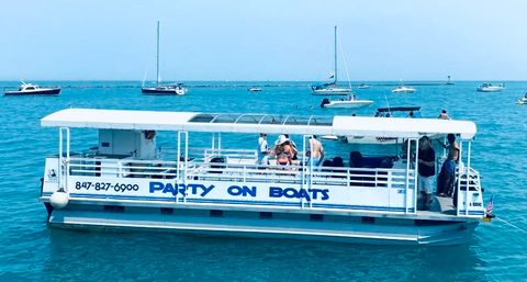 Pontoon party boat with passengers enjoying a sunny summer day on clear blue water, sailboats and motorboats visible on the horizon
