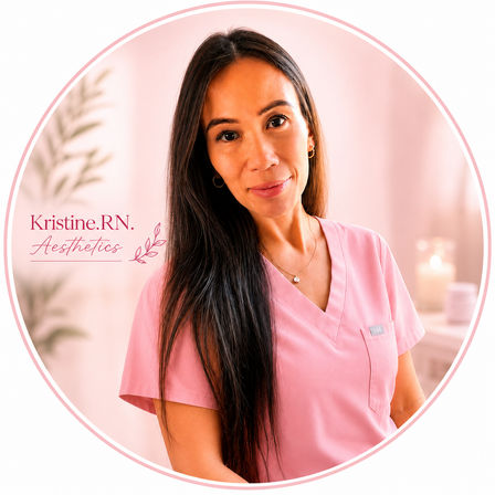 Warm portrait of a woman in pink medical scrubs smiling in a soft, pink-toned spa room, long dark hair, gold hoop earrings and delicate necklace, with blurred candles and a plant in the background — circular profile-style image.