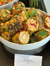 Thai-style grilled corn bites in a white bowl — charred corn pieces tossed with peanuts, cilantro, mint, pickled red onion and lime dressing