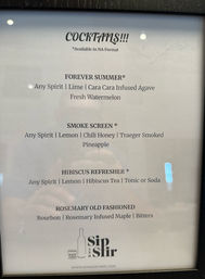 Framed bar cocktail menu on white paper listing four drinks: Forever Summer (any spirit, lime, cara cara infused agave, fresh watermelon); Smoke Screen (any spirit, lemon, chili honey, smoked pineapple); Hibiscus Refresher (any spirit, lemon, hibiscus tea, tonic or soda); Rosemary Old Fashioned (bourbon, rosemary‑infused maple, bitters).