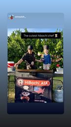 Outdoor hibachi grill station in a backyard: a chef and a smiling child wearing an oversized chef’s hat stand on the griddle with greenery and party decorations behind them, propane tank visible.
