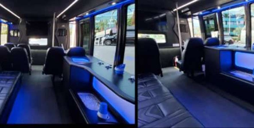 Split-view interior of a luxury shuttle van with black leather seating and captain chairs, built-in counter and cupholders, blue LED accent lighting, and large windows showing an urban street outside.