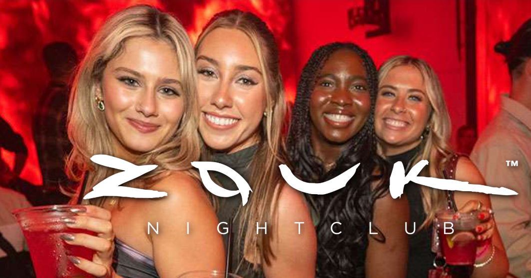 Four smiling women holding cocktails in a red-lit nightclub with a white logo overlay — lively city nightlife scene.