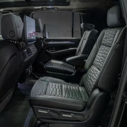 Sleek luxury SUV rear cabin with two black quilted leather second-row captain seats, adjustable armrests and seatback entertainment screens