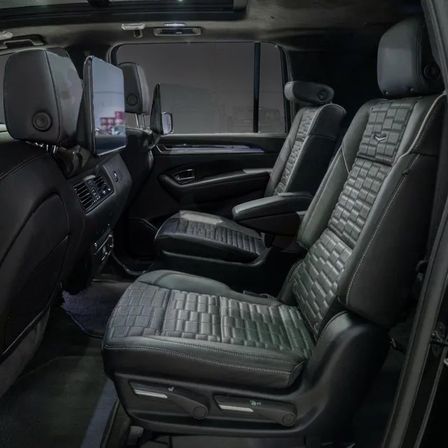Sleek luxury SUV rear cabin with two black quilted leather second-row captain seats, adjustable armrests and seatback entertainment screens