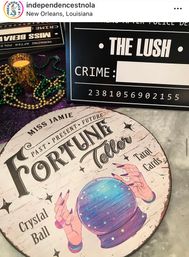 Round vintage fortune-teller sign with a colorful crystal ball illustration, tarot cards, candle and green-and-gold Mardi Gras beads arranged on a table in New Orleans.