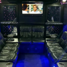 Luxury party bus interior with black leather wraparound seating, blue LED floor lighting, mirrored star-effect panels, cup holders and a wall-mounted TV