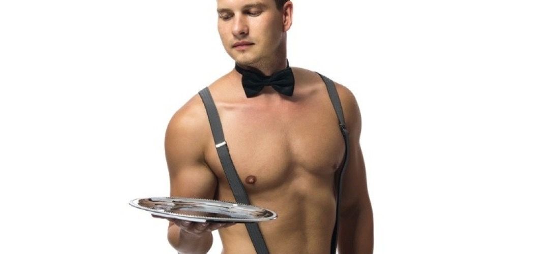 Bare-chested male server wearing a black bow tie and gray suspenders holding a silver serving tray against a white background