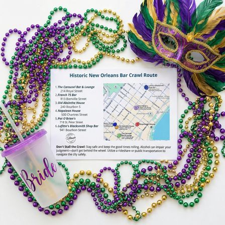 Festive Mardi Gras flat lay with purple, green and gold bead necklaces and a feathered mask surrounding a 'Historic New Orleans Bar Crawl Route' map and a translucent cup labeled 'Bride' — New Orleans party planning theme.