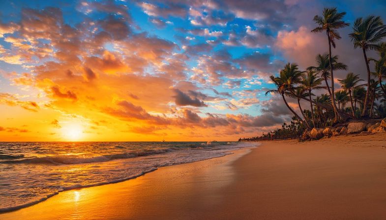 Tropical beach sunset with golden sand, swaying palm trees, colorful clouds and gentle ocean waves