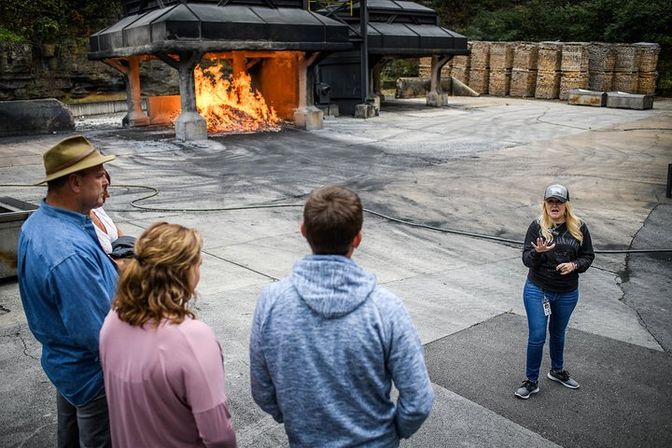 Small group watching a blazing industrial furnace during an outdoor fire-safety training demonstration