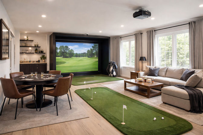 Modern home entertainment room with indoor golf simulator and projector screen showing a golf course, two putting greens and golf bag, poker table with leather chairs, and a cozy sectional sofa by large windows