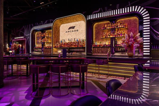 Glam retro‑modern neon-lit cocktail bar interior with backlit marble wall, layered liquor shelves, high tables and velvet stools, purple-pink ambient lighting and decorative floral arrangements.