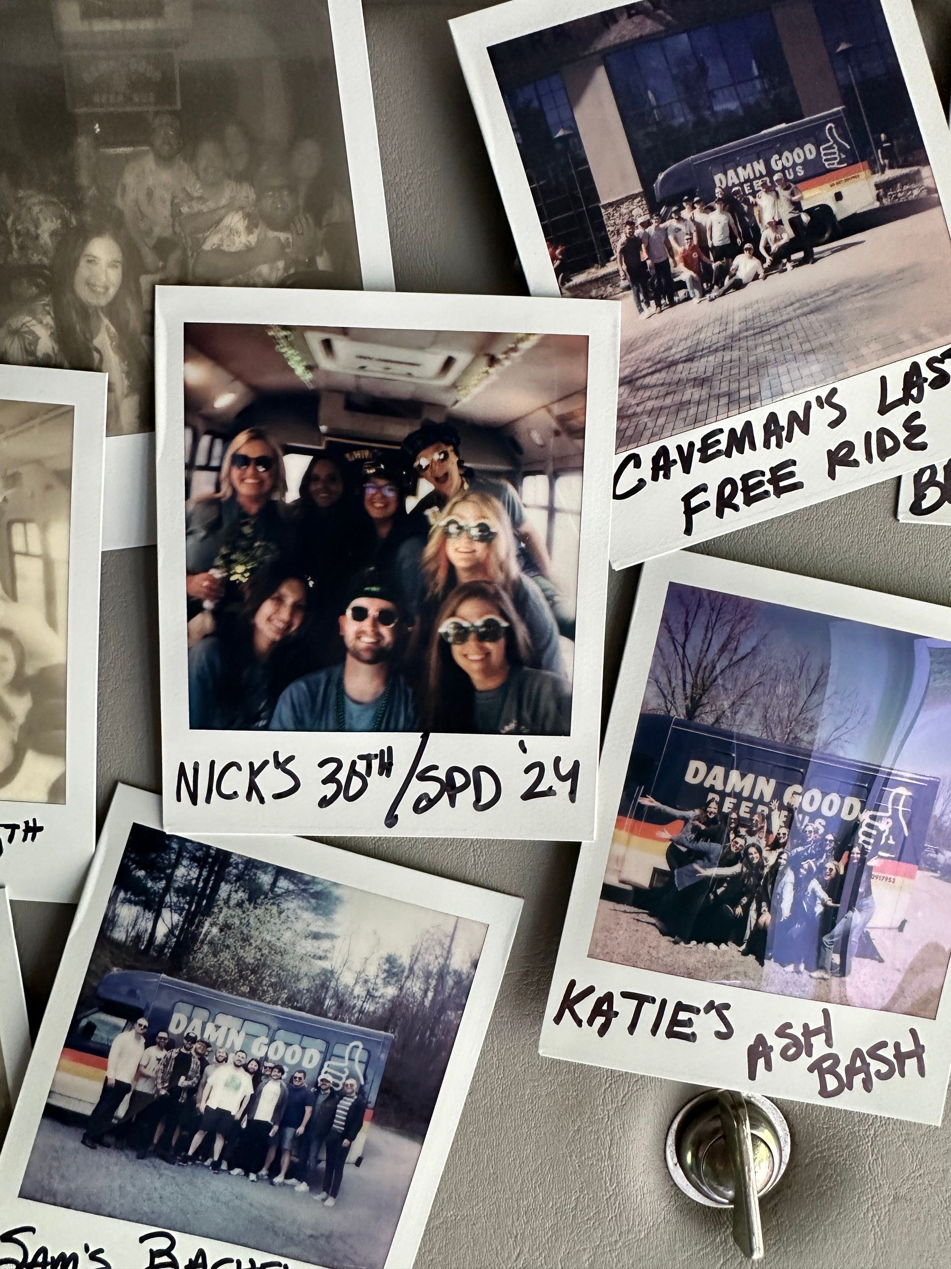 Close-up of instant Polaroid collage on a metal surface held by a round magnet — smiling friends on a party bus and group shots in front of a colorful van with handwritten event captions like 30th and bash