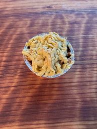 Top-view of a cozy mini crumble-topped pie in a foil tin on a rustic wooden table, bakery-style dessert.
