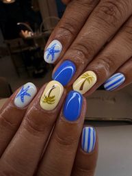 Glossy tropical beach-themed manicure — blue and pale yellow oval nails with starfish, palm tree accents and coastal stripes, summer-ready nail art.