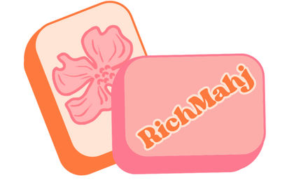 Two stacked pastel soap bars in peach and pink packaging — one shows a stylized pink flower, the other features bold orange script-style lettering on a pastel-pink background.