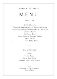 Elegant black-and-white wedding menu card with thin border titled “MENU,” listing starters (grilled boudin, smoked meatballs with smoked crema, sourdough phyllo puff with smoked cream cheese, ahi tuna bites, goat cheese stuffed dates, mini tacos, pork belly bites) and main course (slaw, pesto pasta, burnt end elote, smoked pork tenderloin).