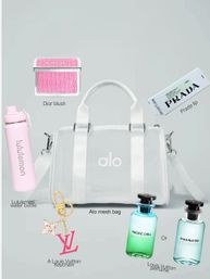 Chic clear white mesh duffel bag styled with a pink blush compact, pale pink water bottle, boxed lip balm, designer keychain and two small perfume bottles on a soft gray background.